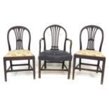 A group of three Georgian mahogany dining chairs, comprising a Hepplewhite style carver with black