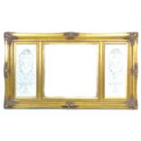 A reproduction gilt overmantle mirror, with bevelled edged glass flanked by two 19th century style