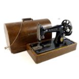 A hand wind Singer sewing machine, circa 1930, serial Y8483734, in oak veneered domed carry case,
