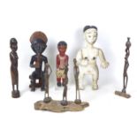 A group of wooden figures mostly African, including a black and white painted figure with her arms