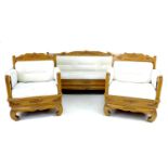 A modern Indonesian three piece suite, with carved foliate decoration, cream overstuffed cushions,