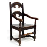 An 18th century and later oak open armchair, with two crescent shaped rails carved with face