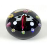 A Paul Ysart style paperweight, the black ground decorated with a butterfly with red body and