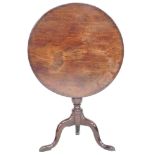 A George III mahogany tilt top occasional table, circular surface on a turned support and tripod