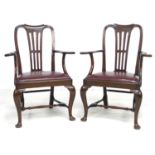 A pair of Edwardian mahogany open armchairs, drop in burgundy leather seats, out-scrolled arms,