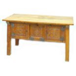 An Arts & Crafts oak sideboard, rectangular surface over three carved panel doors to the front,