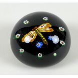 A Paul Ysart style paperweight, the black ground with dragon fly to the centre with orange wings and