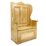 A modern pine box settle, the high shaped wing back with two panels, lift seat and single panel to