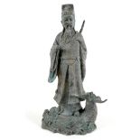 A cast metal sculpture, modelled as the Daoist figure Lu Dongbin standing on a sea monster, with