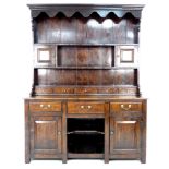 A modern reproduction Georgian style oak Welsh dresser, circa 2000, shaped cornice over a closed