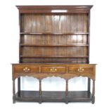 A 18th century oak dresser, with a closed back three shelf top, the base with three frieze drawers