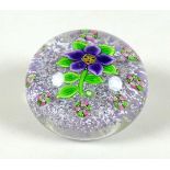 A Paul Ysart style paperweight, the lilac mottled ground with purple flower to the centre, with