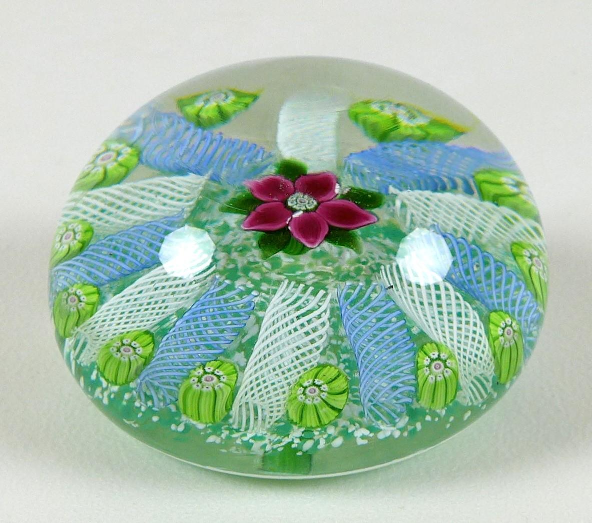 A Paul Ysart style paperweight, the mottled green ground decorated with a central pink flower with