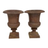 A pair of cast iron garden urns of classical campana form, with well rusted finish, the rim with