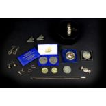 A small collection of silver jewellery and coins, including a sweet wrapper style locket, a necklace