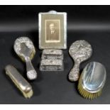 A collection of silver dressing table accoutrements, including a silver photograph frame, stepped