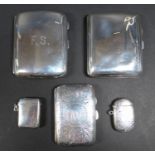 A collection of three silver cigarette cases and two silver vesta cases, one a scrolling foliate