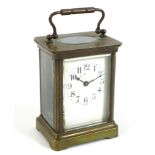 A French Art Deco brass carriage clock, five glass case, the white enamel dial with black Arabic