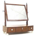 A George III mahogany toilet mirror, of rectangular form, with circular bone feet, 52 by 22.5 by