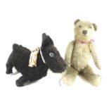 Two early 20th century soft toys, one a black dog, 23cm tall, the other a bear, 38cm tall. (2)