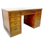 An Edwardian walnut pedestal desk, with green leather inlaid top and nine drawers, 138 by 72 by 76cm