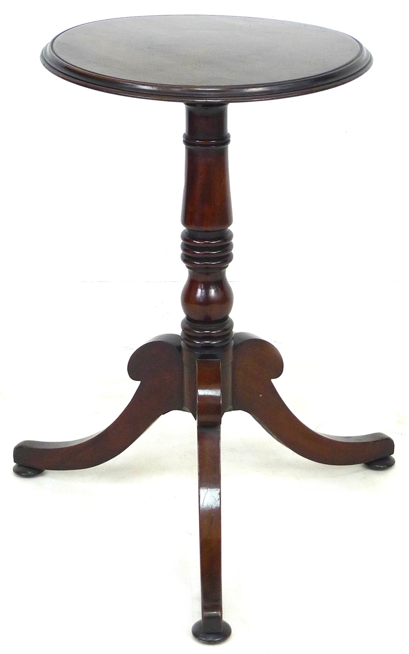 A mahogany wine table, the circular surface with moulded edge, raised on a turned column and three