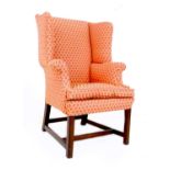 A Georgian wing armchair, of small proportions, upholstered in salmon pink and gold fabric, raised