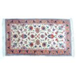 A small Persian rug, cream floral decoration, signed to one end, 80 by 150cm.