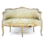 A French 19th century giltwood two seater settee, Louis XV style canape, with floral carved frame,