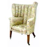 A George III wing armchair, with high 'ribbed' barrel back, upholstered in pale green, blue, pink