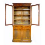 A Victorian mahogany and walnut veneered bookcase, twin glazed doors enclosing three shelves, twin