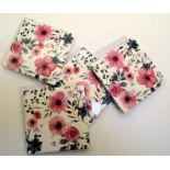 Set of 4 ceramic coasters with red rose designs. 4 rubber cushion pads on bottom. Stored in