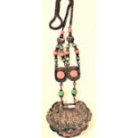 A Chinese pendant with large coral and turquoise stones. On one side of the pendant is an