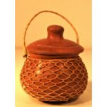Small ceramic pot covered with fine natural string net. Probably from Lombok. 6 x 9cm. New.