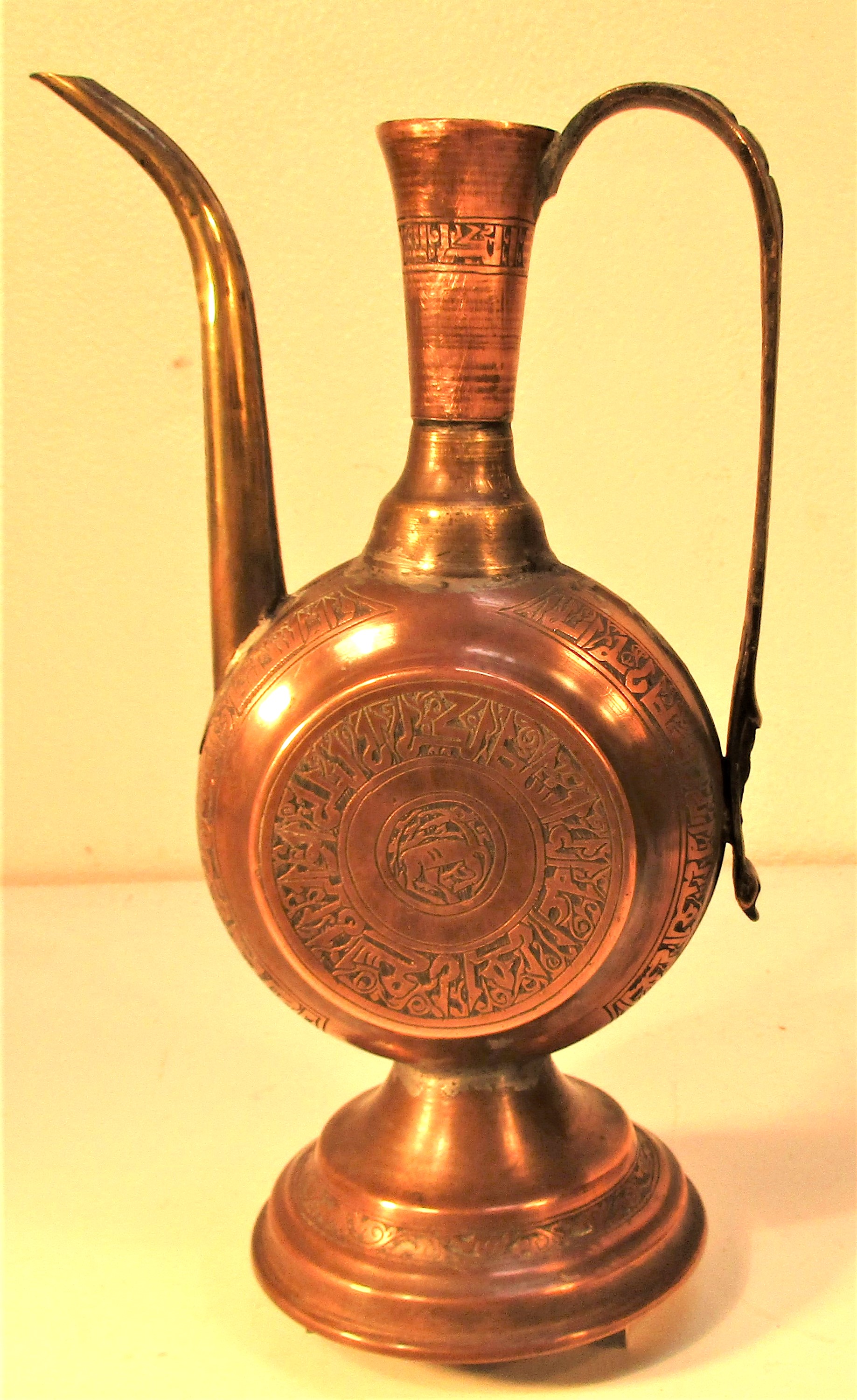 An elegant Turkoman rose water jug. Etched brass with Islamic script and dancing deer. 26 x 15cm.