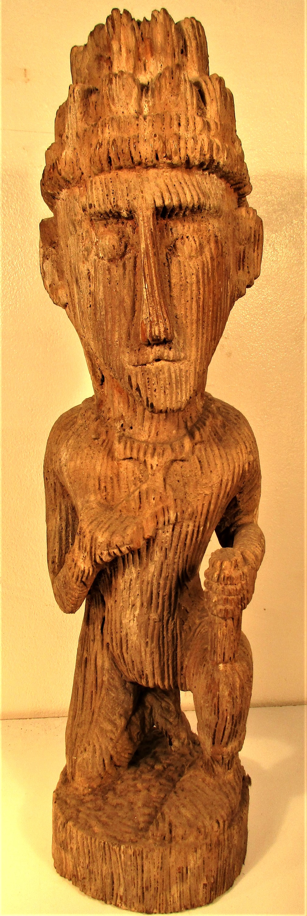 Sulawasi sculpture of a kneeling man. It appears as though this sculpture has been washed in the sea