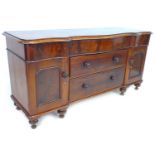 A Victorian mahogany sideboard, with serpentine front, drawers flanked by two cupboards enclosing