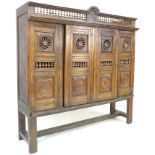 A French oak cupboard, 19th century and later, with carved and baluster detail, bears carved date '