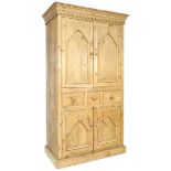 A modern pine cupboard, in Victorian style, with twin cupboard doors opening to reveal a single