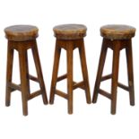 Three vintage oak bar stools, with leather upholstered seats, 30 by 30 by 76cm high. (3)