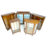A group of five vintage glazed display cabinets, 1940's to 1960's, most with glass shelves, 60 by