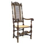 A walnut 17th century style armchair, with carved decoration and caned seat and back, 59 by 66 by