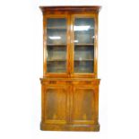A Victorian mahogany and walnut veneered bookcase, twin glazed doors enclosing three shelves, twin