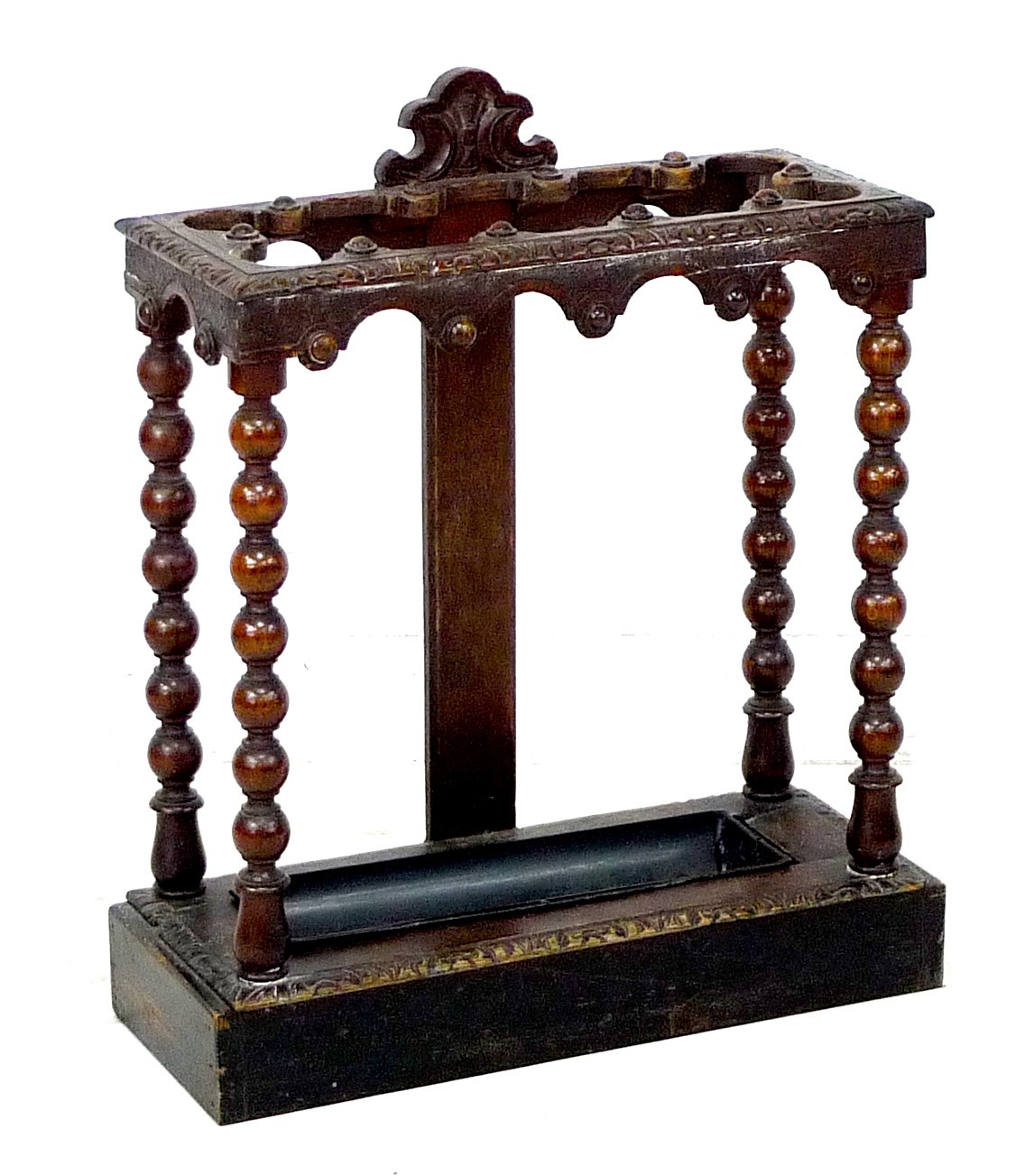 A late Victorian carved oak umbrella stand, with bobbin turned supports and removable drip tray,