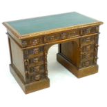 An early 20th century oak twin pedestal desk, three frieze drawers, each pedestal with four drawers,