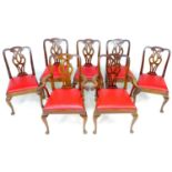 A set of seven mahogany dining chairs, in the Georgian style, with red leather drop in seats,