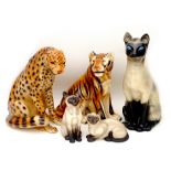 A group of five china feline figurines, comprising three Siamese cats, largest, a/f, 22 by 16 by