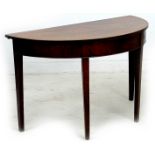 An early 19th century mahogany demi lune side table, plain frieze, raised on tapering square section