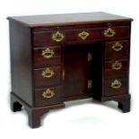 A George III mahogany kneehole desk, with pull out slide, long drawer over central recess with