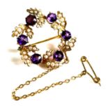 An Edwardian 9ct gold, amethyst and seed pearl wreath brooch, approximately 2.5cm diameter, with